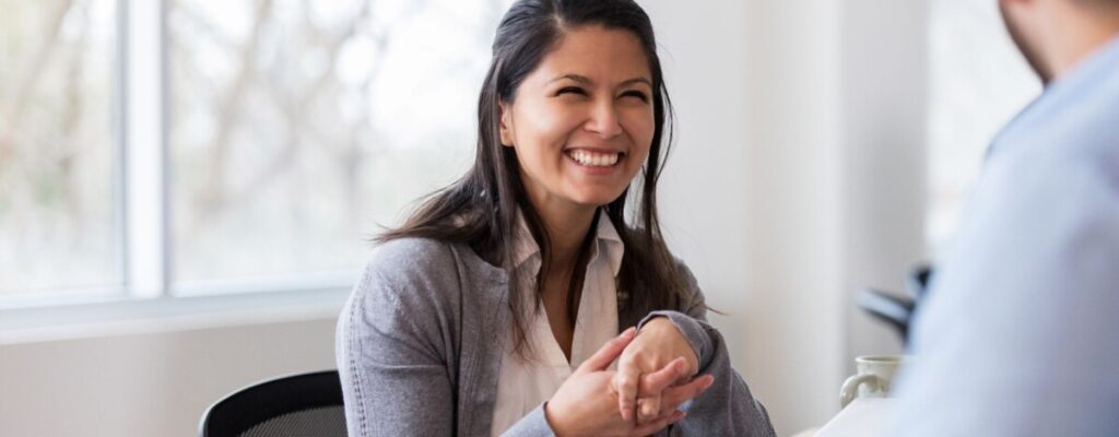 Woman chatting at a table with another employee