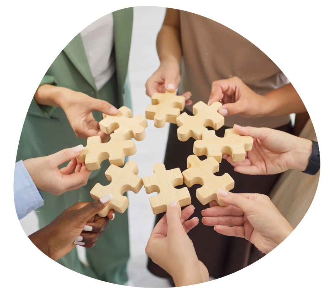 employees hands holding pieces of a puzzle in a circle